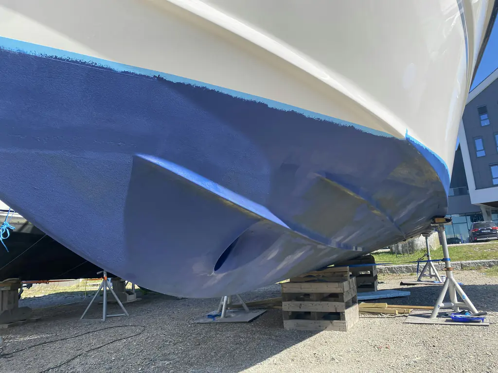 Casco de una embarcación recién pintado con antifouling azul